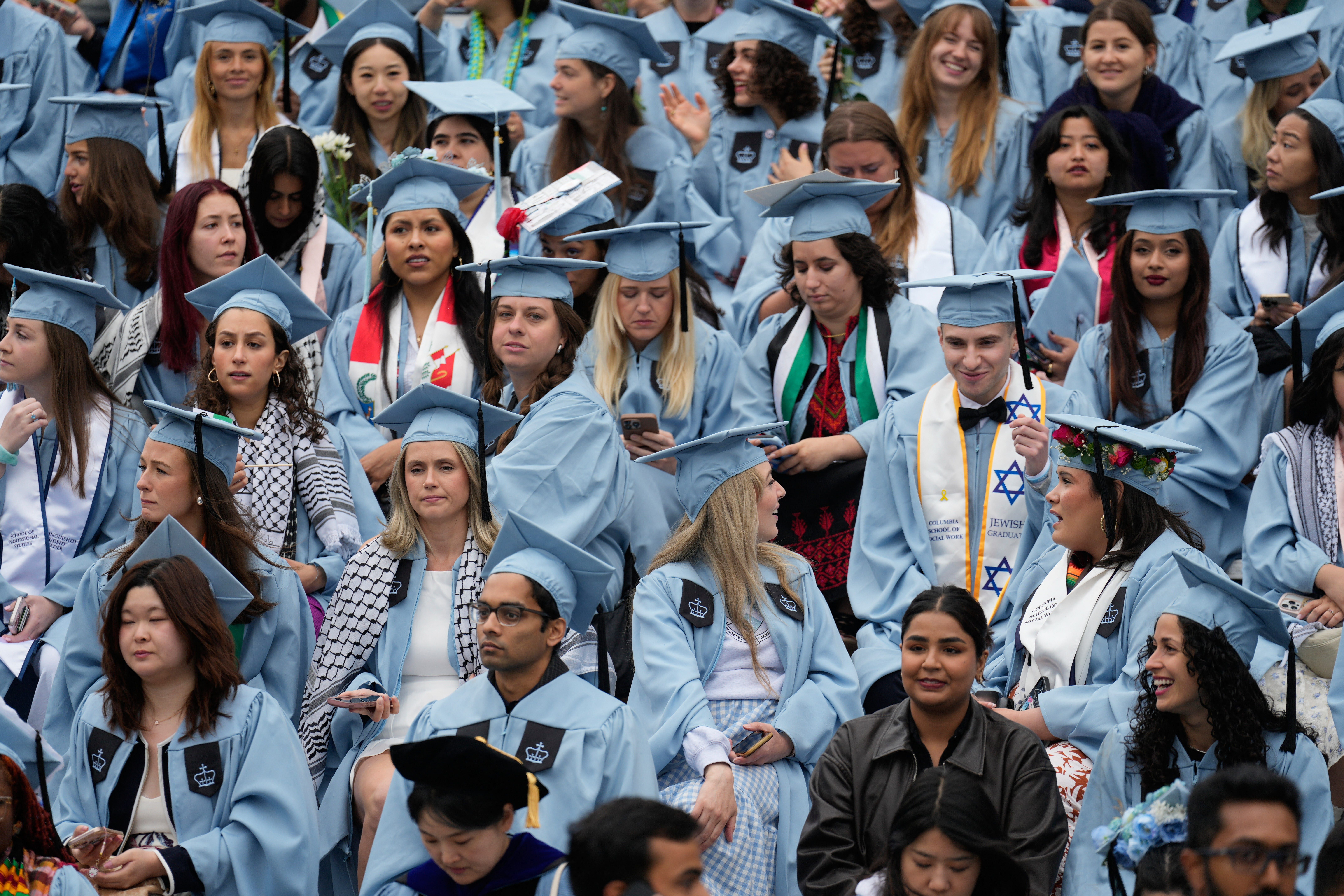 Alunos assistem à cerimônia de formatura na Columbia University, enquanto novas regras de visto estudantil são implementadas. Reprodução: Business Insider