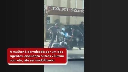 Guardas imobilizam mulher após luta corporal na entrada da prefeitura em Espírito Santo do Pinhal.; Reprodução: Globo