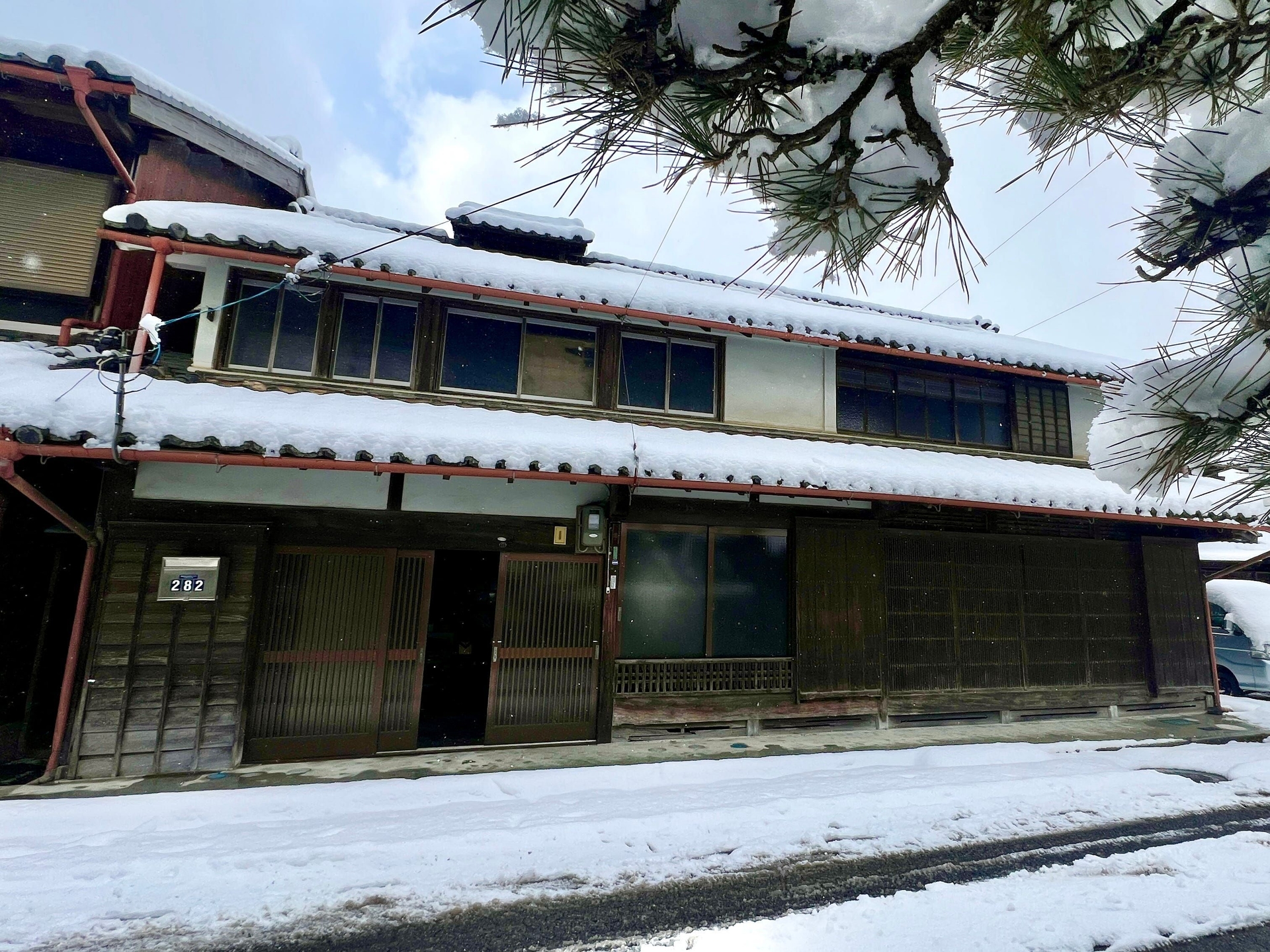 Coline Aguirre ao lado da tradicional casa japonesa que comprou para restaurar. Reprodução: Business Insider