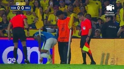Funcionário e jogador da Seleção consertam bandeira de escanteio durante partida entre Equador e Brasil. Reprodução: Globo
