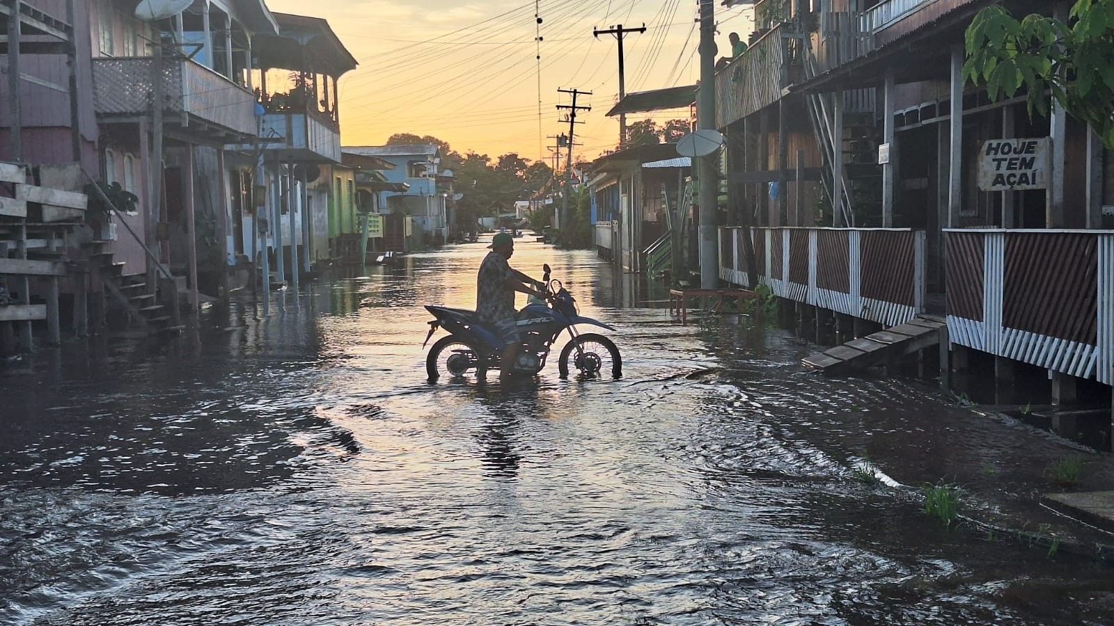 Moradores de Anamã se divertem em ruas alagadas, transformando a cheia em um momento de lazer. Reprodução: Globo