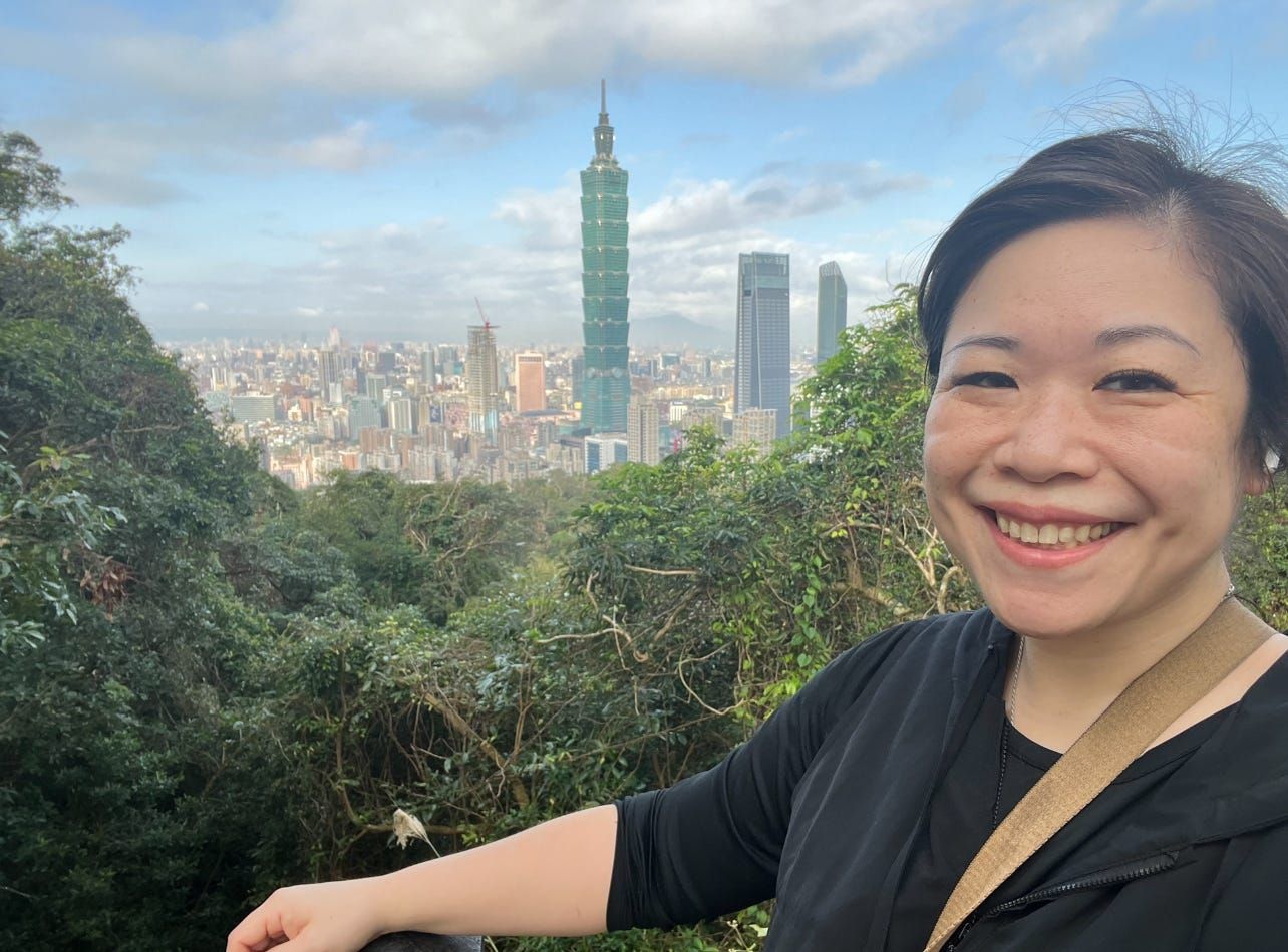 Catherine Shu posa com o Taipei 101 ao fundo, refletindo sua jornada de vida na cidade. Reprodução: Business Insider