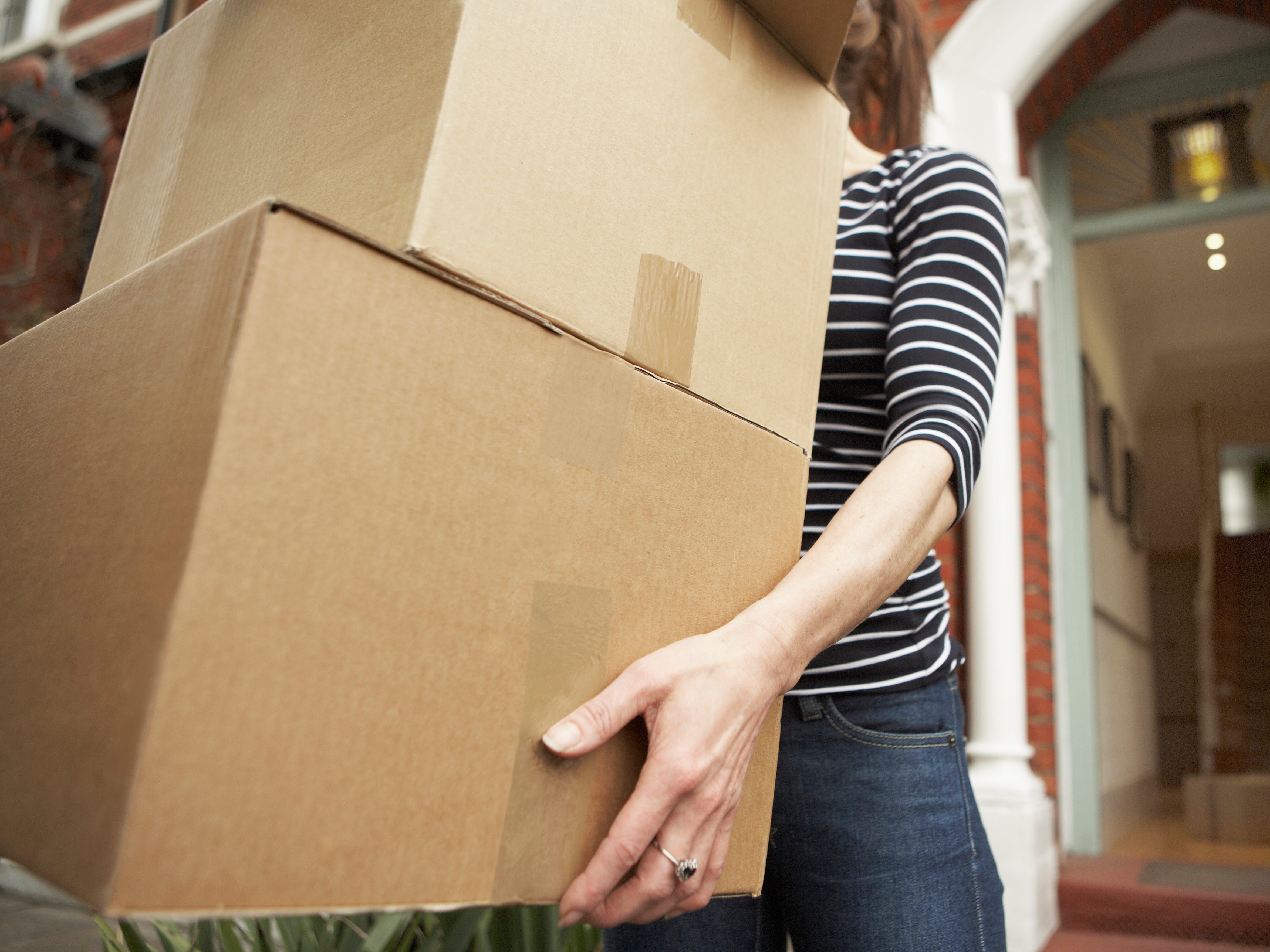 Mulher empacotando caixas de papelão, preparando-se para mais uma mudança. Reprodução: Nick White