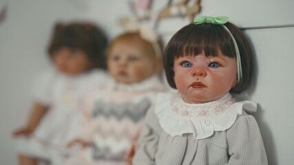 Mulher passeia em Itaquera com boneca reborn, atraindo olhares curiosos. Reprodução: Globo