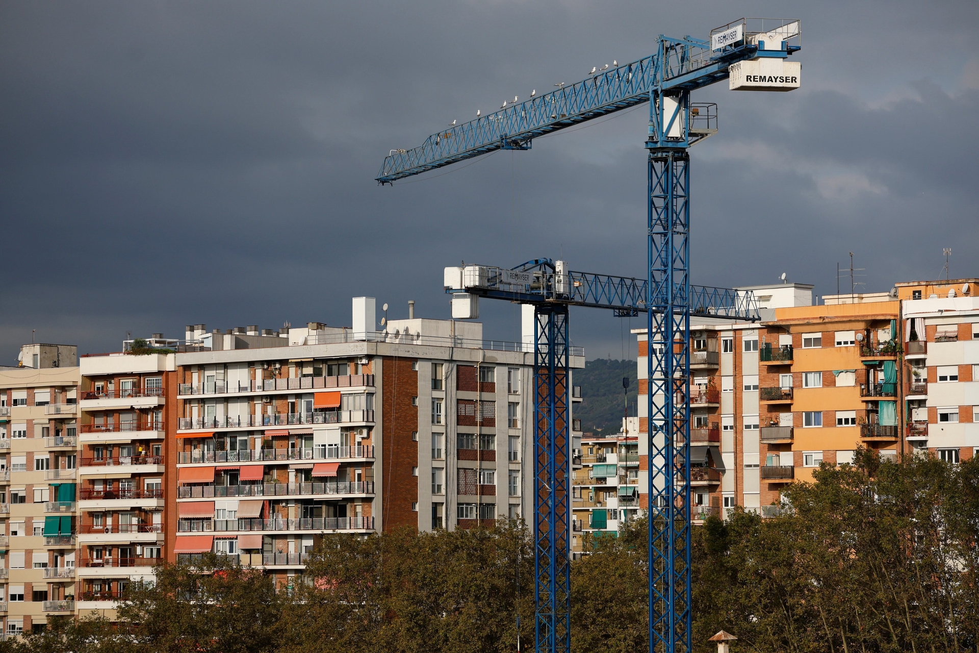 Poblenou, Barcelona: guindastes em obra diante de prédios de habitação protegida. Legenda da imagem. Reprodução: Retorno do item 11