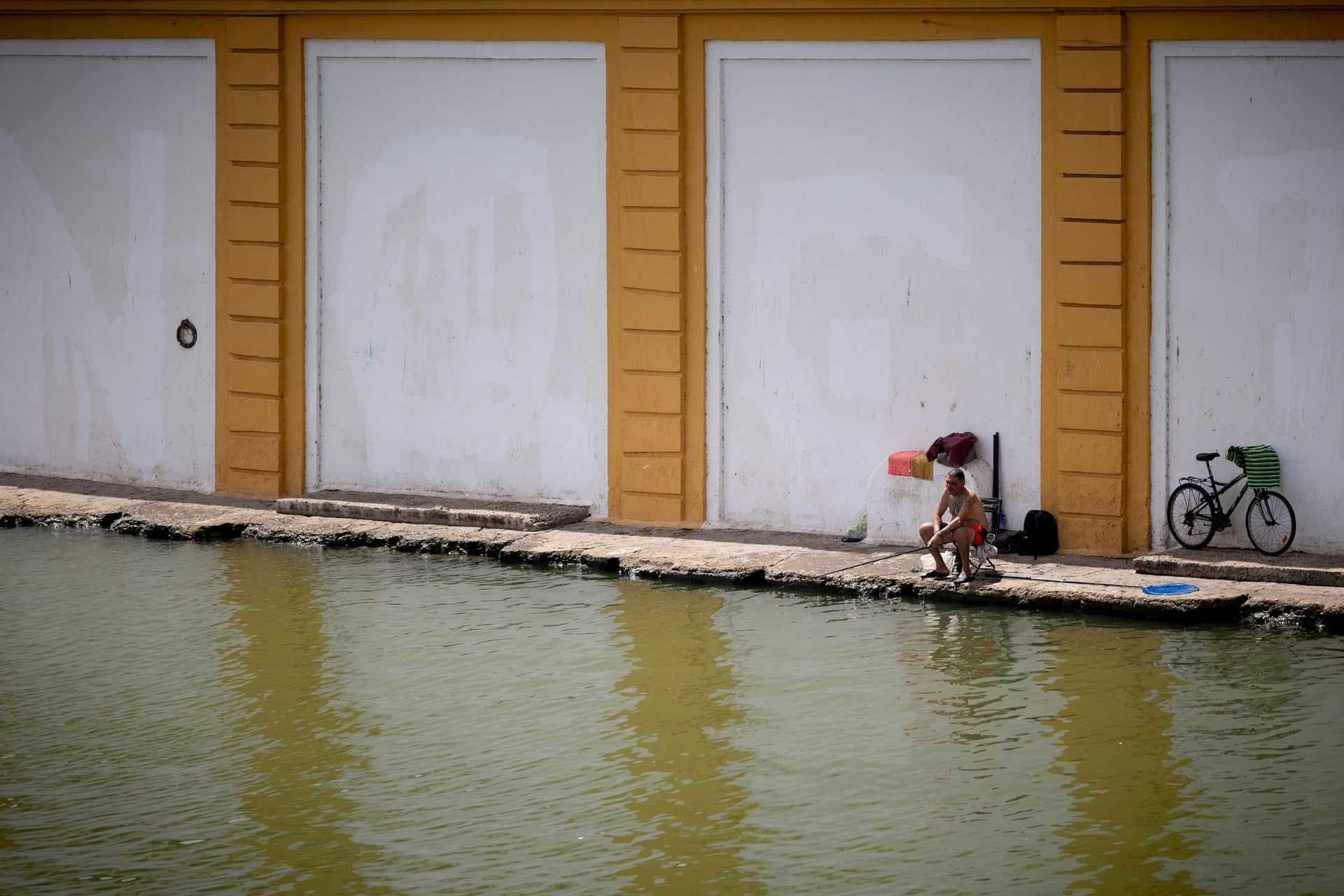 Um homem pesca na orla do Guadalquivir em meio a alerta de calor extremo em Sevilla. Reprodução: El País