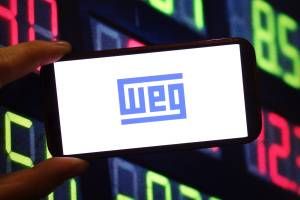 Logo da WEG exibido em smartphone com fundo de números coloridos em tela digital.