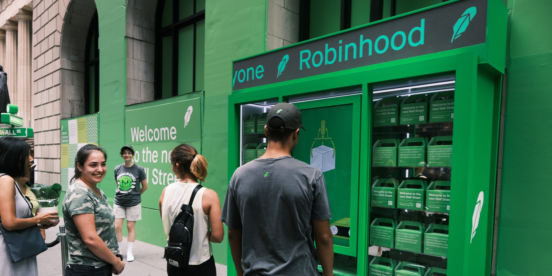 Pessoas fazem fila para receber camisetas do Robinhood em Wall Street após IPO da empresa. Reprodução: Business Insider