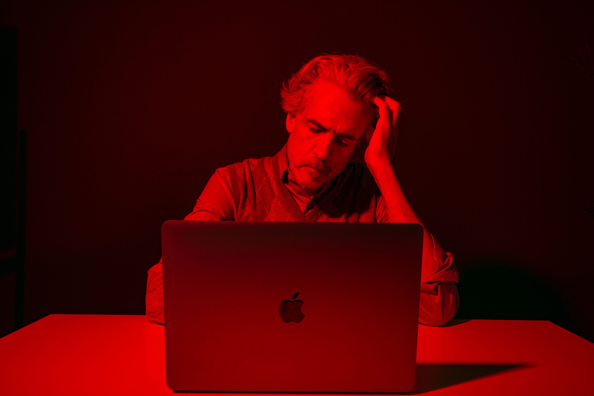 Quant hedge funds enfrentam perdas significativas, com um homem refletindo sobre a situação diante do laptop. Reprodução: Business Insider