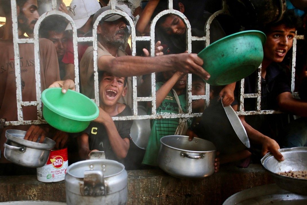 Palestinos se aglomeram em busca de comida em cozinha comunitária na Faixa de Gaza. Reprodução: Globo