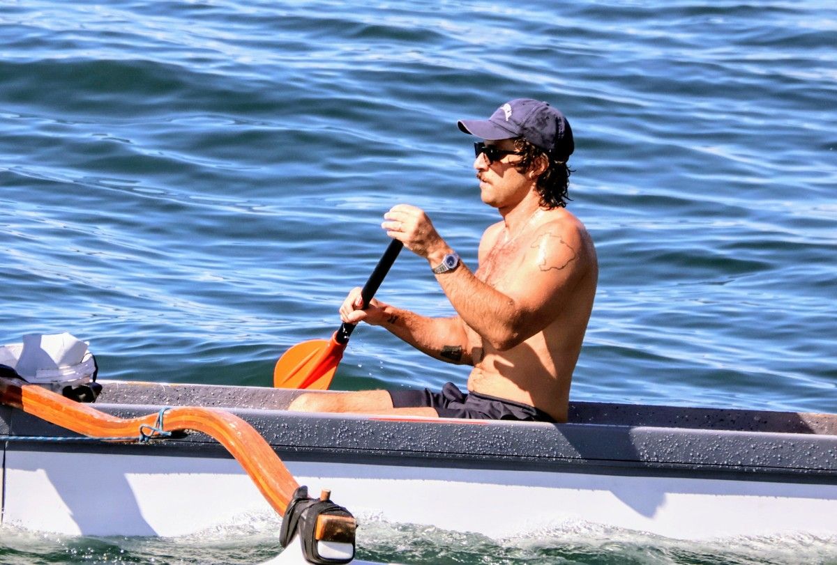 Chay Suede pratica canoagem em praia carioca