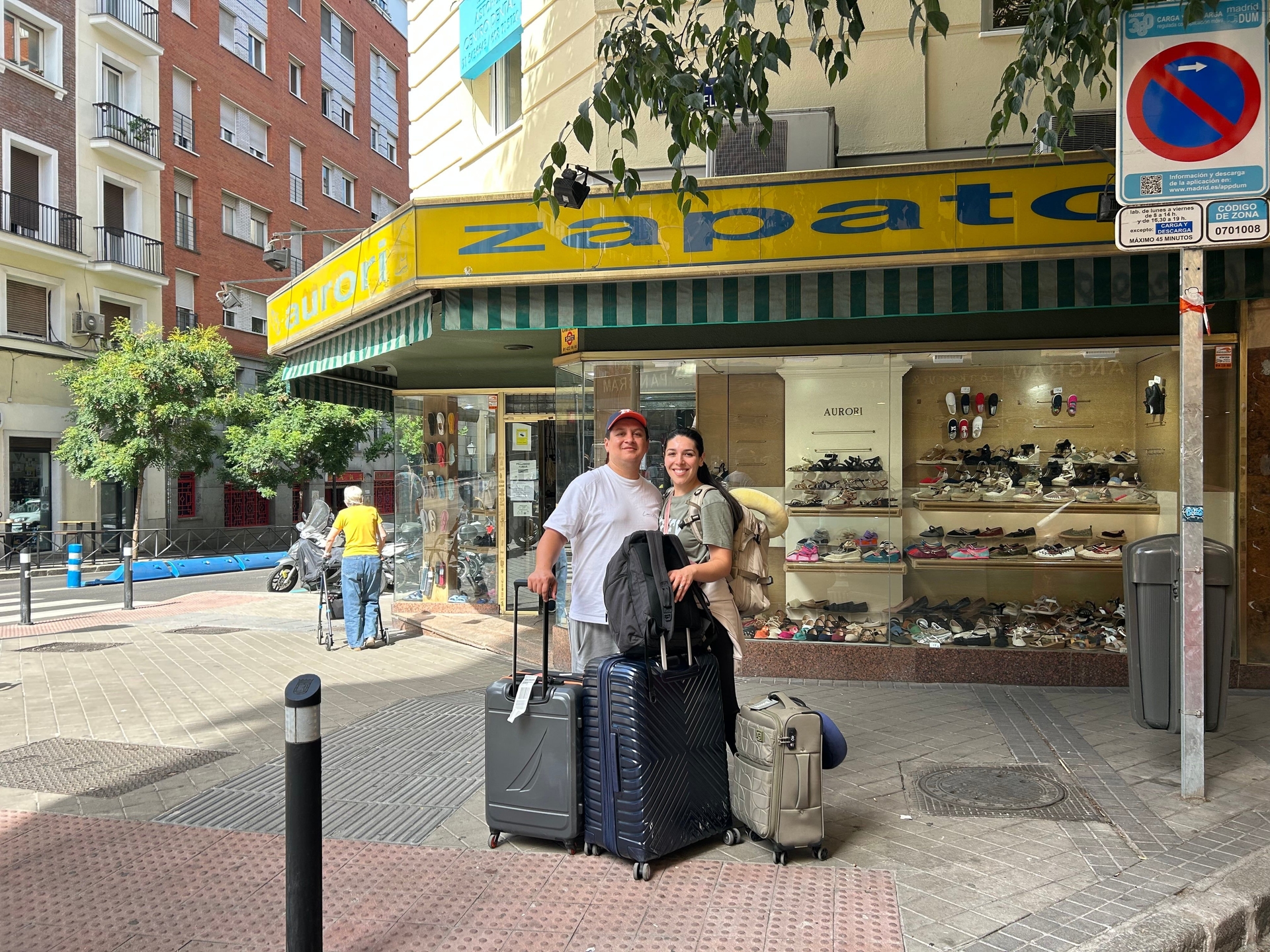 Casal à frente da Zapatería Aurori em Moncloa, atraindo curiosidade de passantes. Reprodução: El País