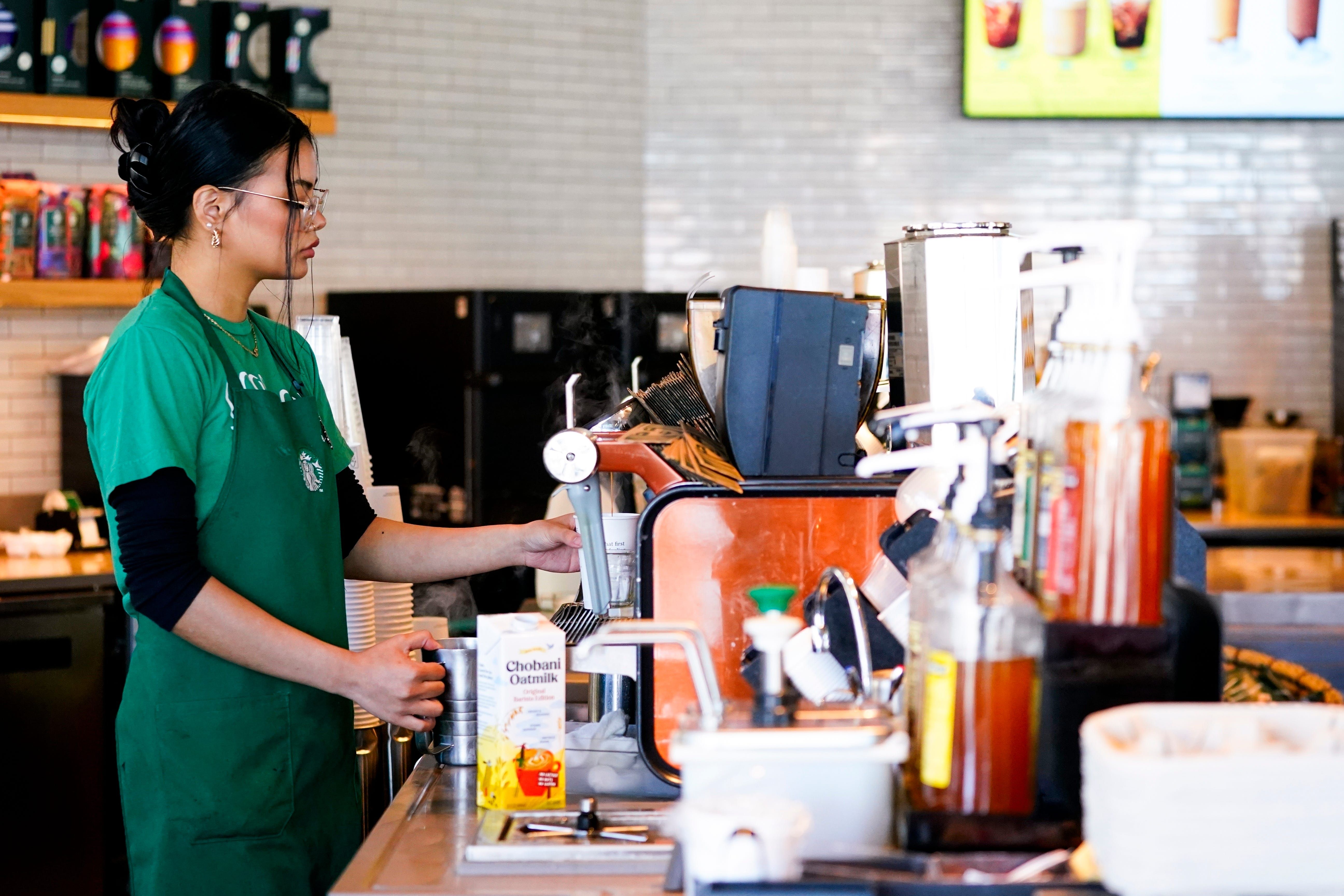 A barista prepara café em máquina espresso após Starbucks abolir taxa para leites não lácteos. Reprodução: Business Insider