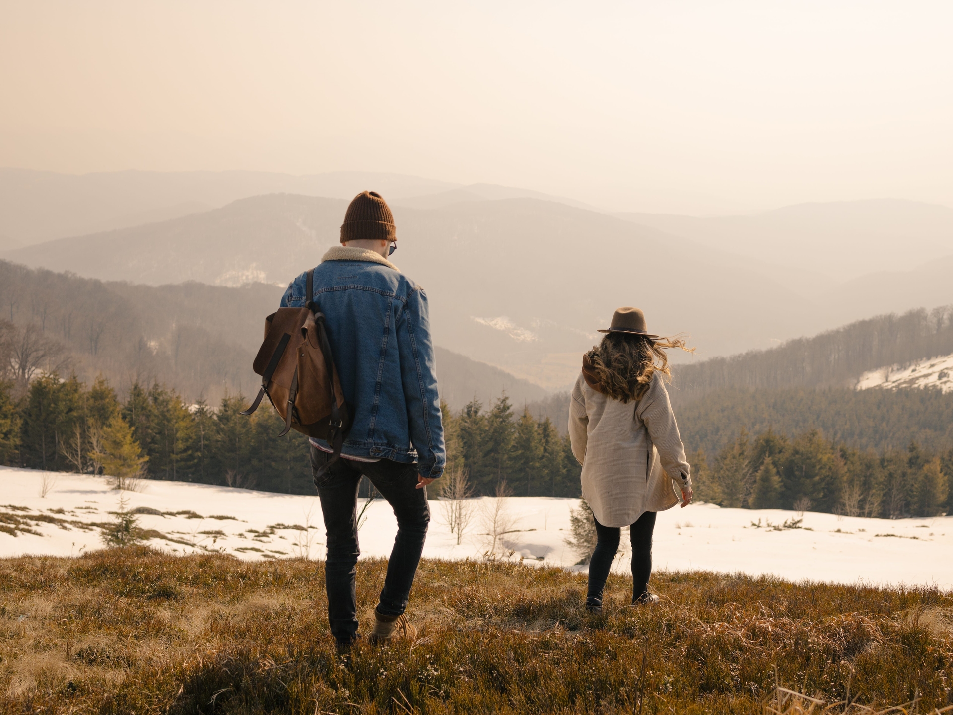 Casal caminha em direção às montanhas, refletindo sobre como a mudança para uma cidade pequena fortaleceu seu casamento. Reprodução: Serhii Mazur/Getty Images