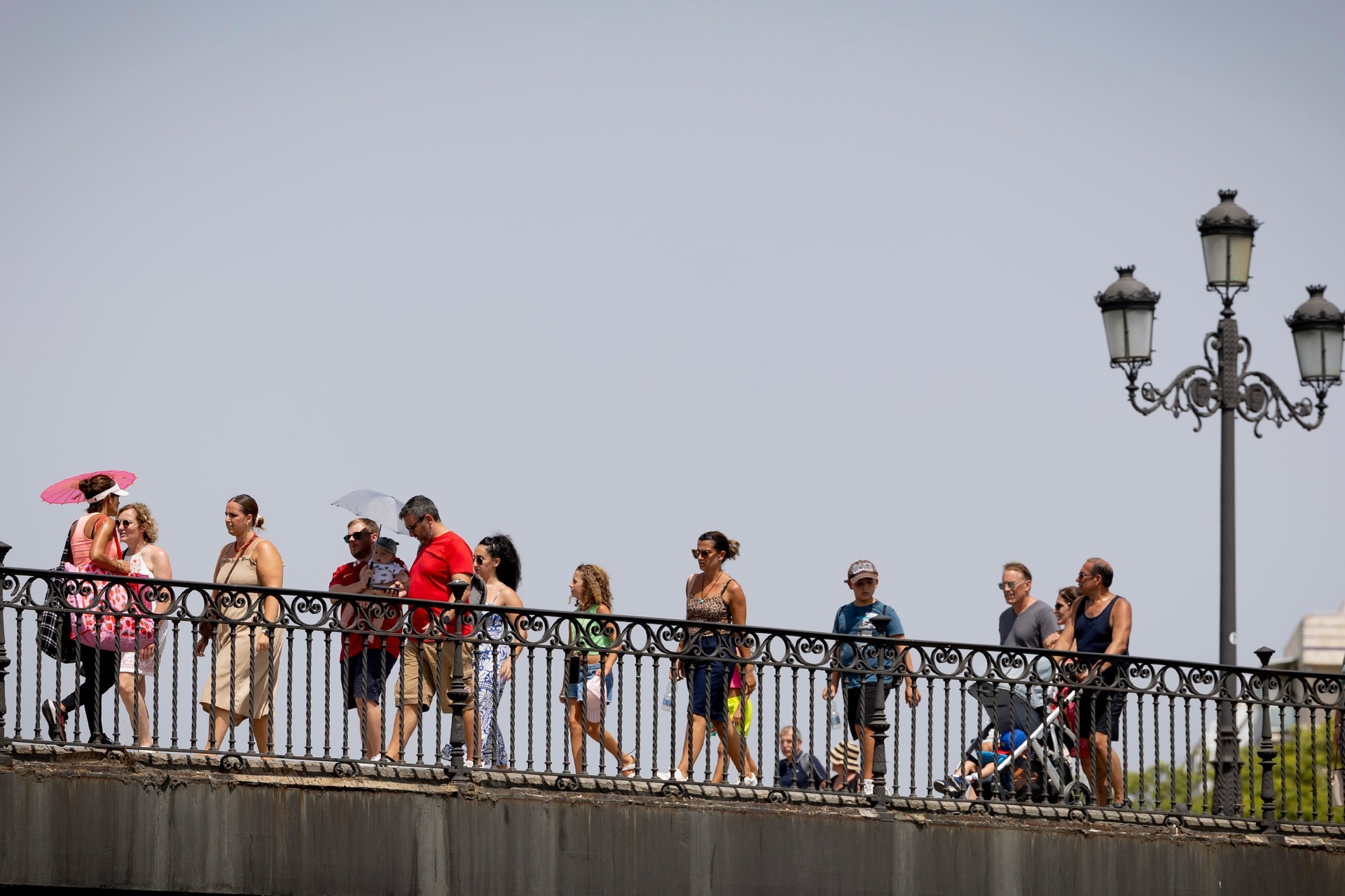Paseantes buscam alívio do calor intenso no puente de Triana, em Sevilla.; Reprodução: El País