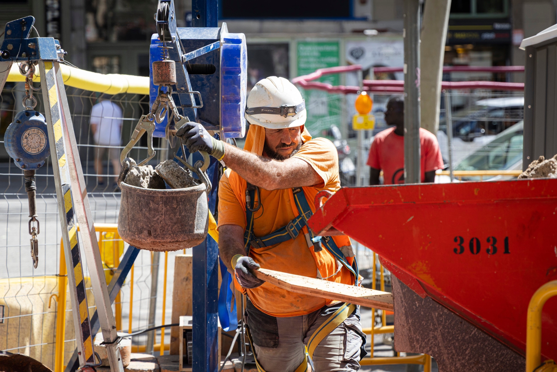 Trabalhador se protege do calor em obra na Calle Sepúlveda, Barcelona. Legenda da imagem. Reprodução: Retorno do item 11