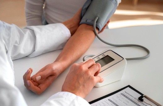 Profissional de saúde mede pressão arterial de paciente em consulta clínica.