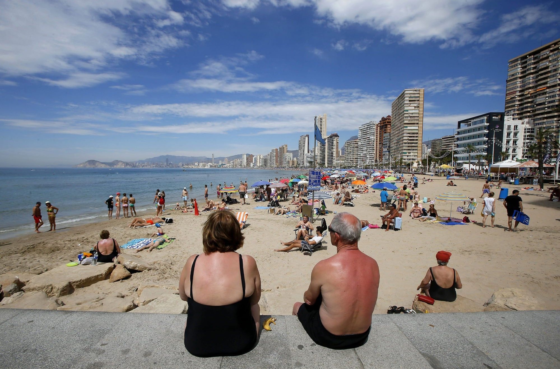 Turistas desfrutam da praia em Benidorm, enquanto se prepara a nova edição de viagens para idosos. Legenda da imagem. Reprodução: El País