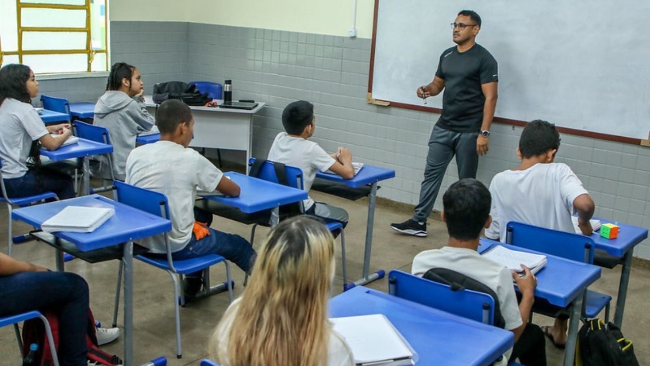 Professor tira dúvidas de alunos em sala de aula durante a preparação para a Prova Nacional Docente. Reprodução: Eliton Santos/Semed
