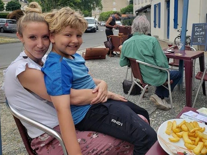 Mãe e filho se divertem em um restaurante, ilustrando a importância do apoio na paternidade. Reprodução: Crystal Hoshaw