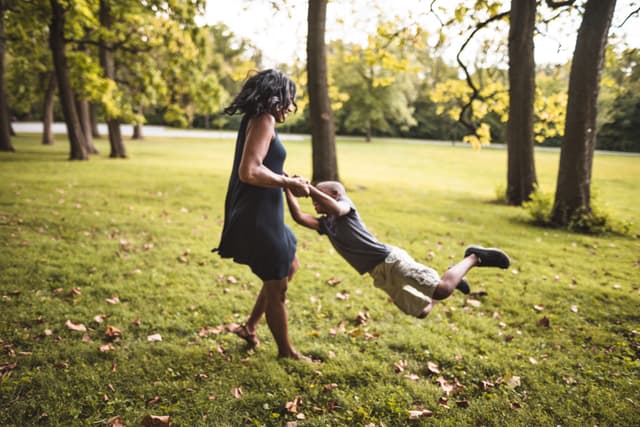 Mãe brinca com o filho em um parque, refletindo sobre a experiência de criar um menino. Reprodução: Business Insider