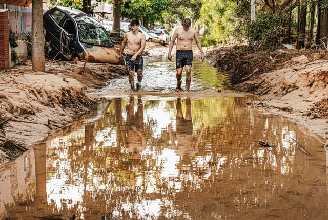 Jovens enfrentam a lama em Picanya após as inundações ocasionadas pela dana em Valencia. Legenda da imagem. Reprodução: El País