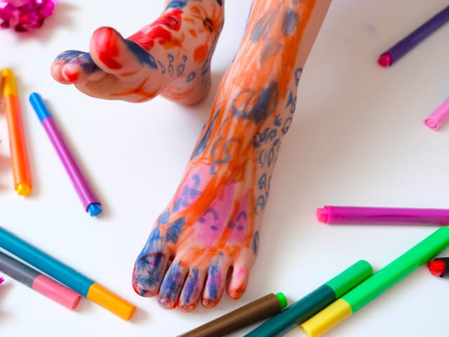 Crianças se divertem desenhando com marcadores laváveis nos pés. Legenda da imagem. Reprodução: Business Insider