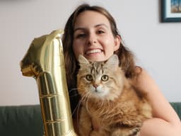 Mulher realiza festa de aniversário para seu gato, refletindo sobre sua jornada social e superação da solidão. Reprodução: Julia Pugachevsky