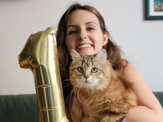 Mulher realiza festa de aniversário para seu gato, refletindo sobre sua jornada social e superação da solidão. Reprodução: Julia Pugachevsky