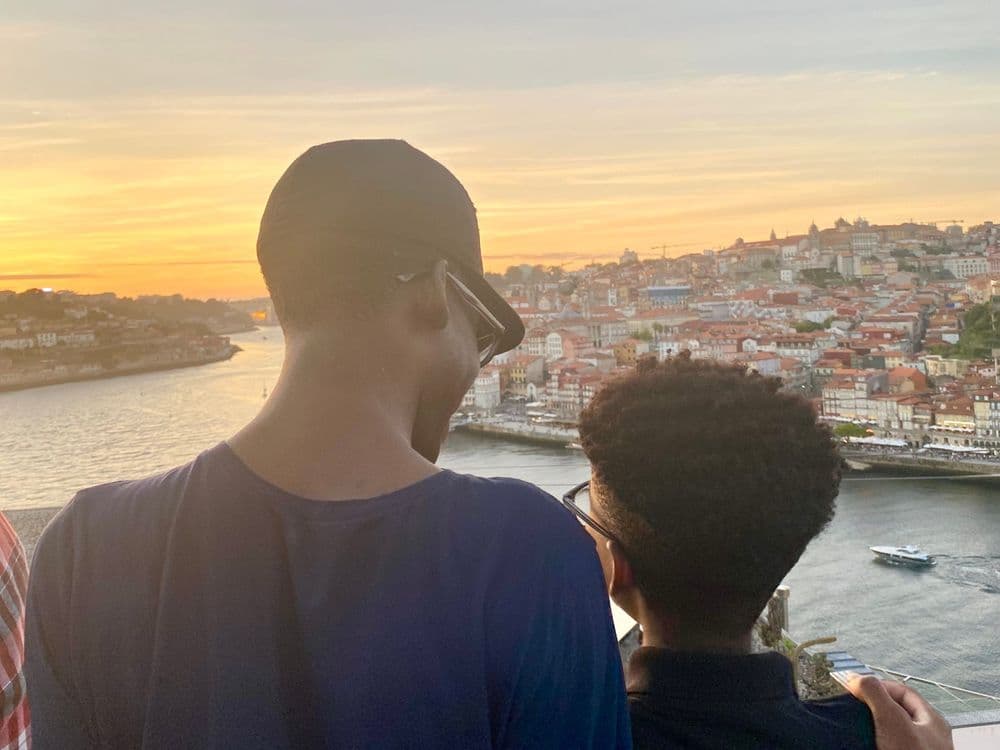 Mãe e filhos assistem ao pôr do sol em Portugal, refletindo sobre a importância da expressão emocional. Reprodução: Lisa White