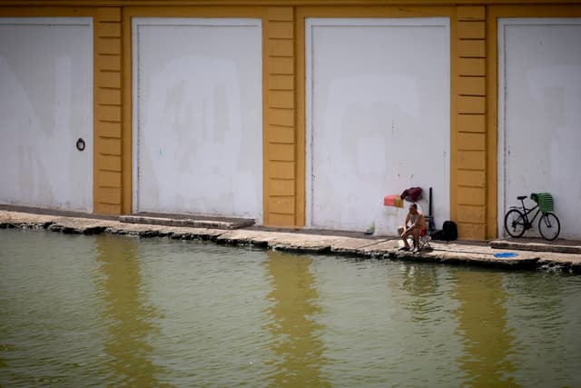 Um homem pesca na orla do Guadalquivir em meio a alerta de calor extremo em Sevilla. Reprodução: El País