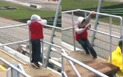 Menino quase perde o equilíbrio ao filmar carros da NASCAR devido à forte rajada de vento.; Legenda da imagem. Reprodução: iG Esportes