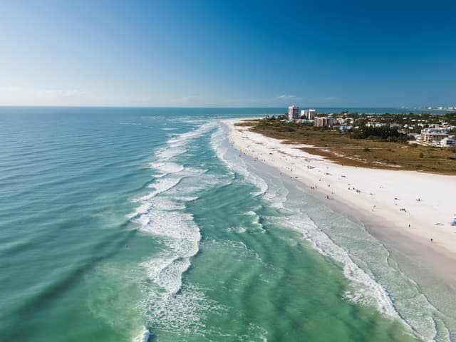 Siesta Key Beach, renomada como a melhor da EUA, encanta visitantes com suas areias brancas e águas calmas. Reprodução: Business Insider