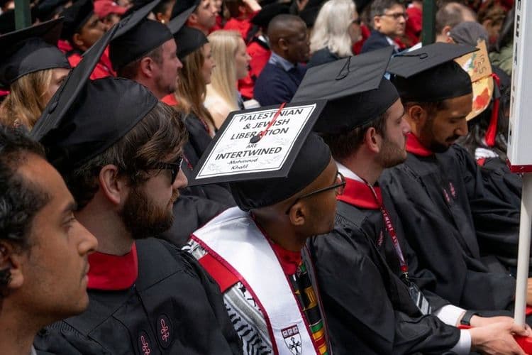 Toque de resistência: estudante usa boné de formatura para exibir mensagem política. Reprodução: Globo