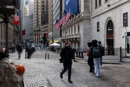 Pessoas caminham pela New York Stock Exchange, em meio à volatilidade do mercado. Reprodução: Business Insider