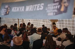 Mshai Mwangola exibe capas de jornais durante palestra no festival Macondo em Nairobi. Reprodução: Retorno do item 11