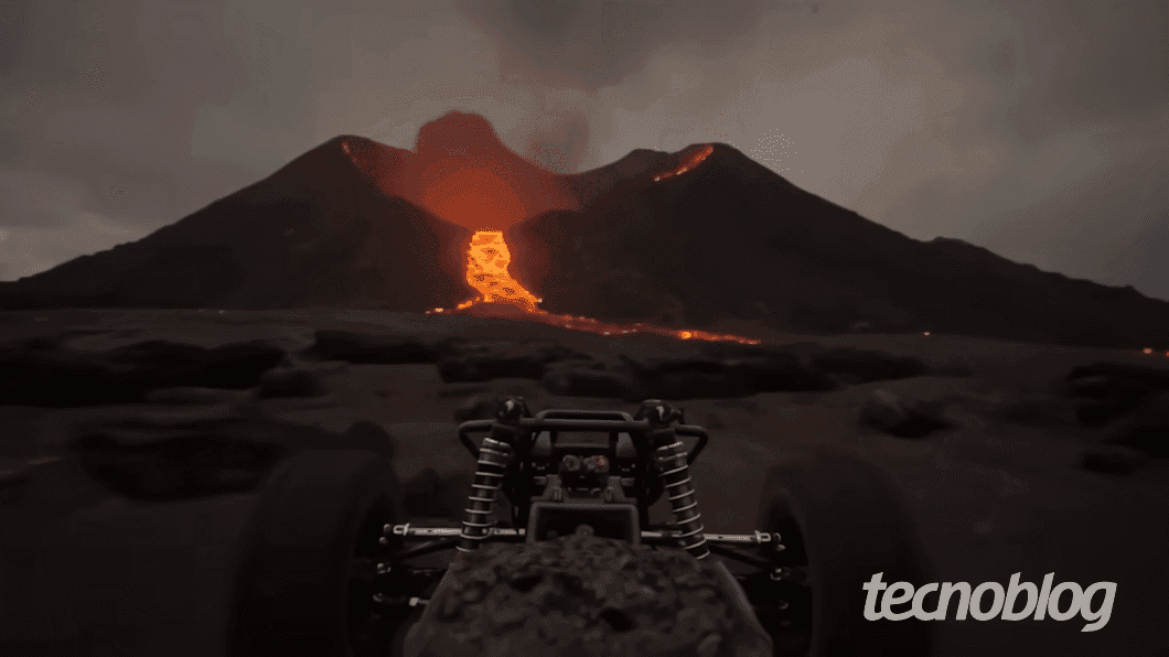 Carro de controle remoto navega em cenário gerado pelo Genie 3, com vulcão em erupção ao fundo. Reprodução: Tecnoblog