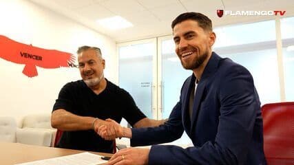 Jorginho visita o Ninho do Urubu e assina contrato com o Flamengo ao lado de Filipe Luís. Reprodução: Globo