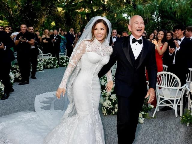 Jeff Bezos e Lauren Sánchez caminham após cerimônia de casamento em Veneza, destacando extravagância e poder. Reprodução: Business Insider