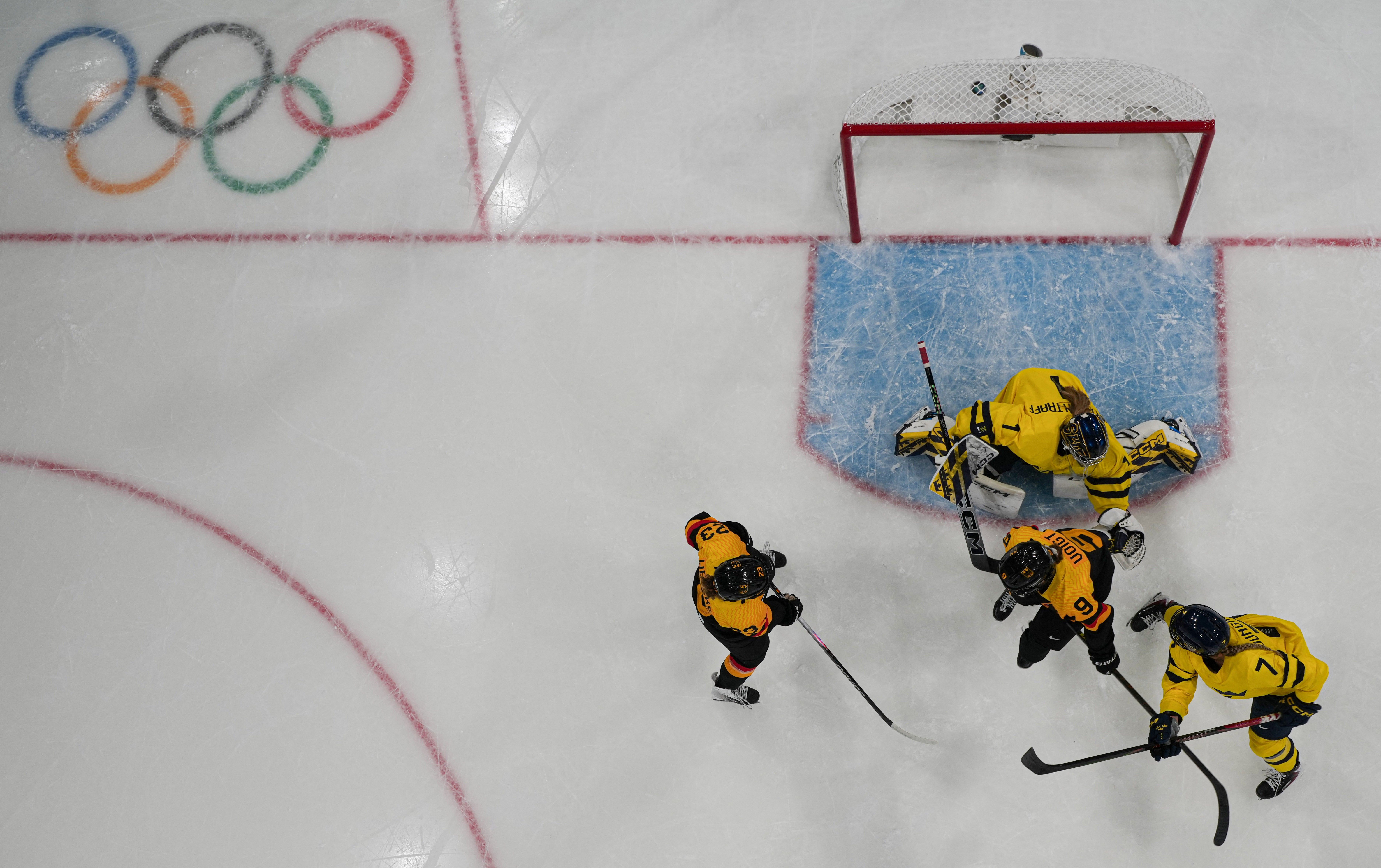 Jogadores de hóquei no gelo em ação nas Olimpíadas de Inverno 2026. Reprodução: Ge