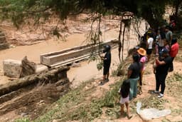 Moradores observam o local do desabamento de ponte após cheia do rio Pirai, na Bolívia.. Reprodução: Oglobo