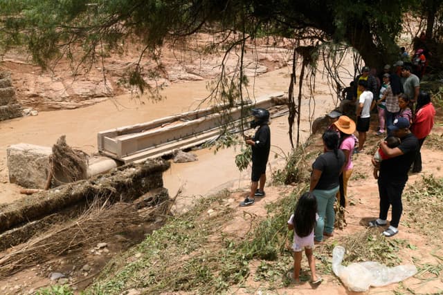 Moradores observam o local do desabamento de ponte após cheia do rio Pirai, na Bolívia.. Reprodução: Oglobo
