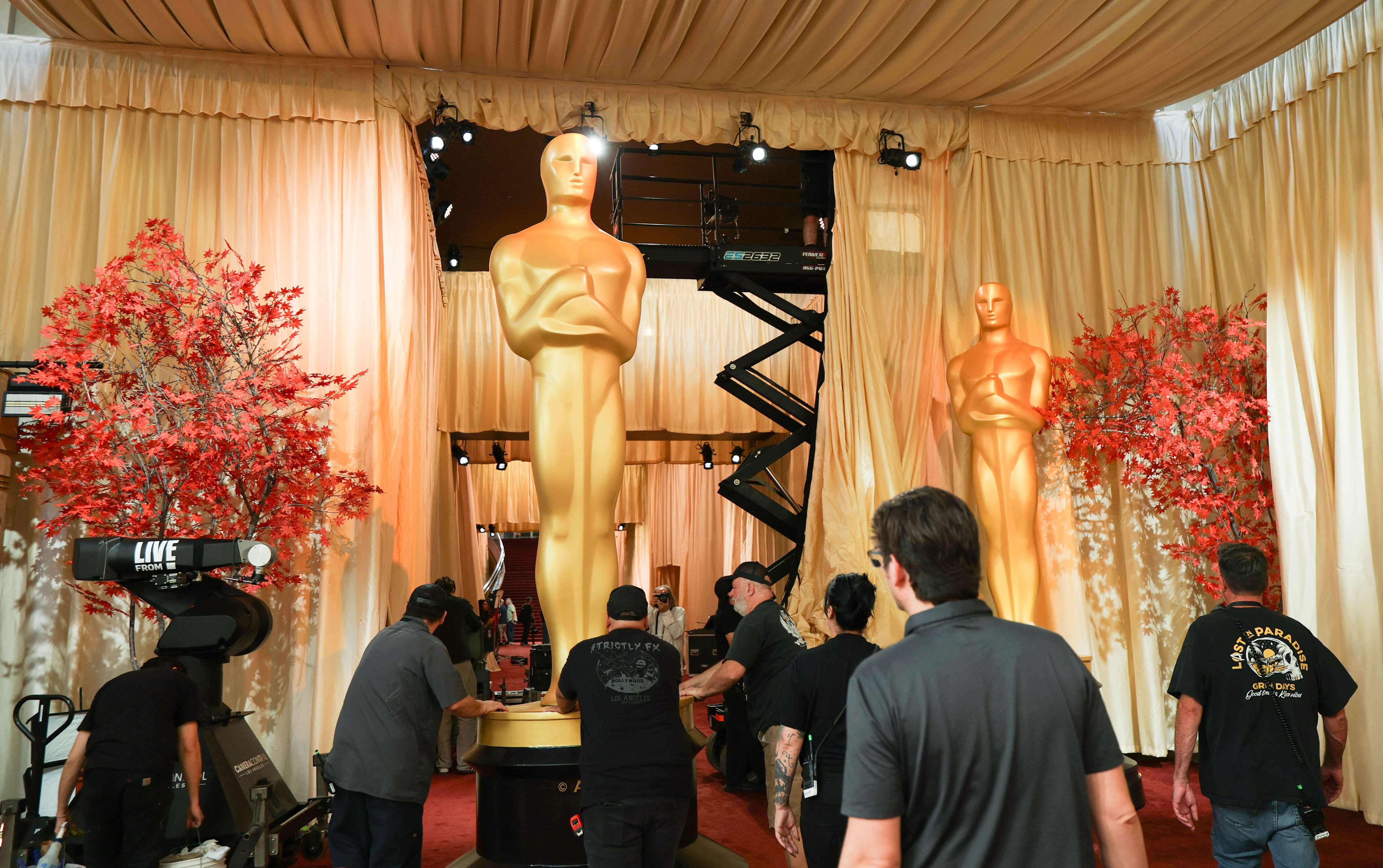 Trabalhadores erguem estátua do Oscar diante do Dolby Theatre, em Los Angeles, antes da cerimônia. Reprodução: Oglobo