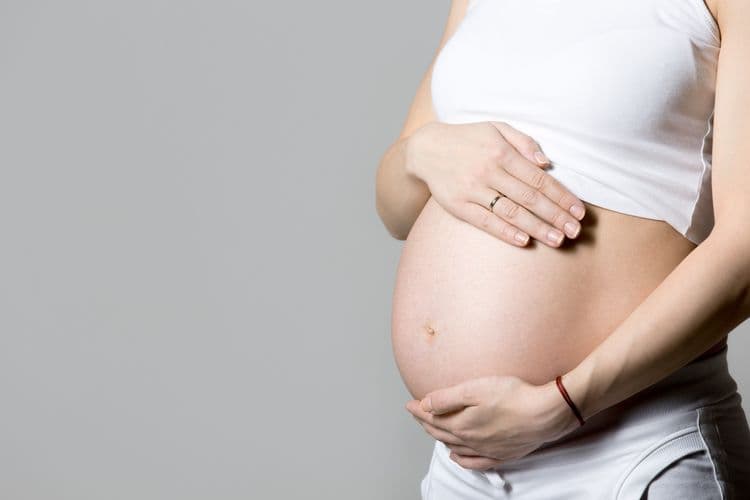 Mulher grávida toca a barriga enquanto alerta para riscos do uso indiscriminado de suplementos na gestação. Reprodução: Globo