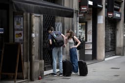 Turistas em frente a um piso turístico em Barcelona, alvo de ações contra anúncios ilegais. Reprodução: El País