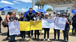 Candidatos chegam ao Enem em São Carlos, cercados por voluntários antes da prova. Legenda da imagem. Reprodução: Retorno do item 11