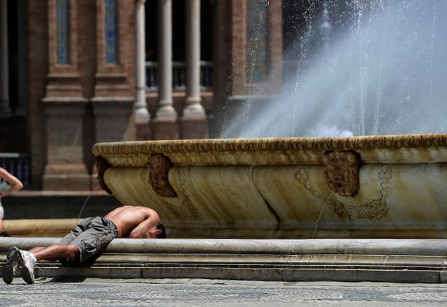 Jovem se refresca na fonte da Plaza de España para enfrentar o calor. Legenda da imagem. Reprodução: Retorno do item 11