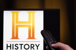 Logo do History Channel na TV e controle remoto mostram pauta sobre IA, não alienígenas. Reprodução: Gizmodo