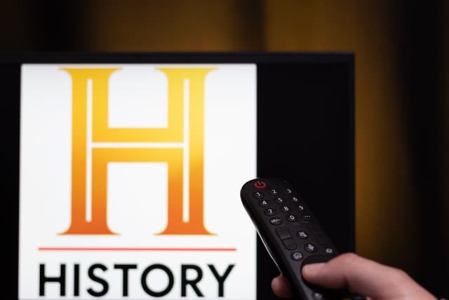 Logo do History Channel na TV e controle remoto mostram pauta sobre IA, não alienígenas. Reprodução: Gizmodo