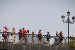 Paseantes buscam alívio do calor intenso no puente de Triana, em Sevilla.; Reprodução: El País